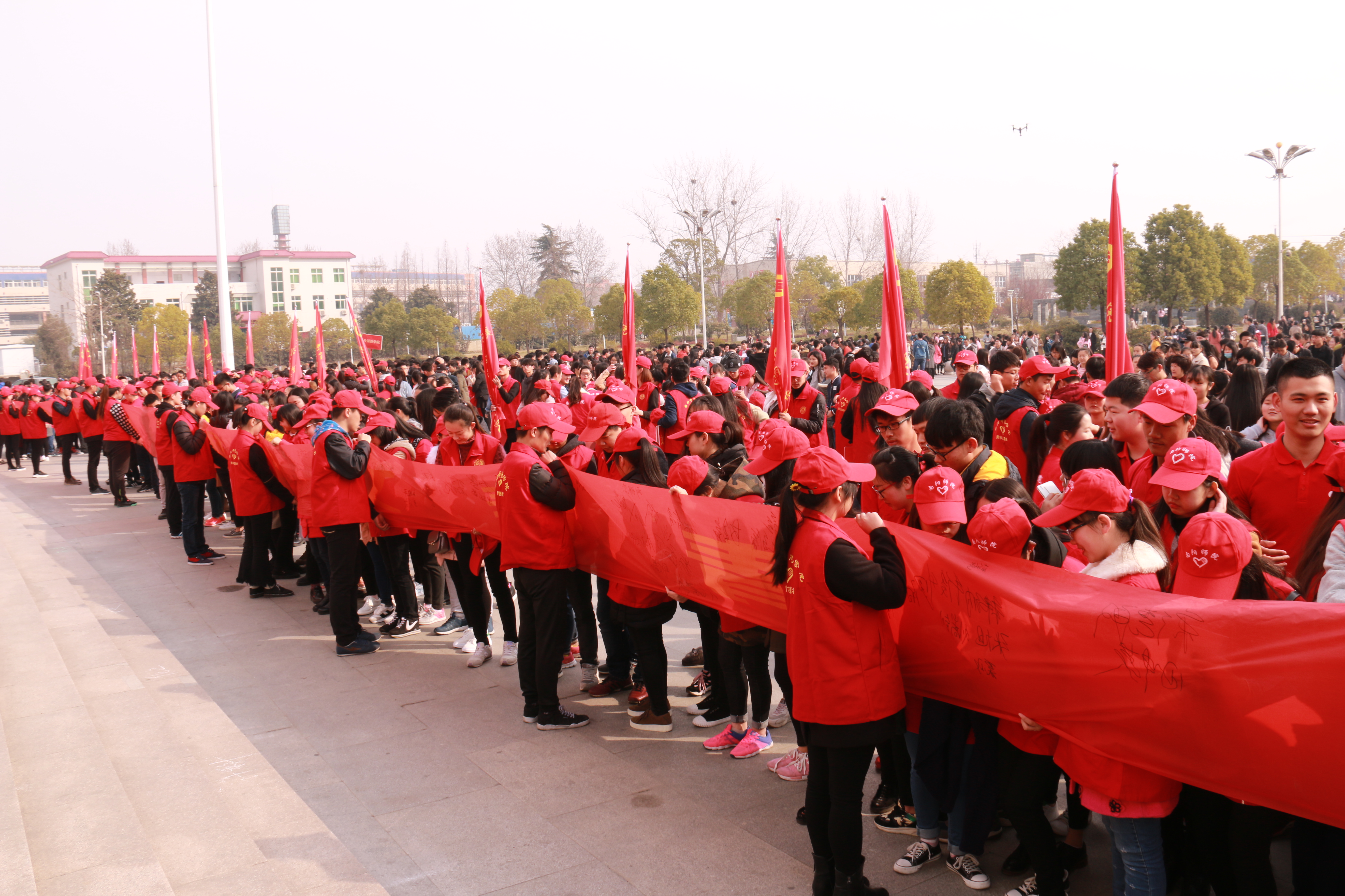 7志愿者在“青春文明同行  践行志愿精神”条幅上签名.JPG